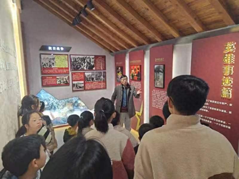 35名中小學(xué)生在家長的陪同下，正在認(rèn)真聆聽一老一小“紅色故事宣講員”講史家村故事1.jpg