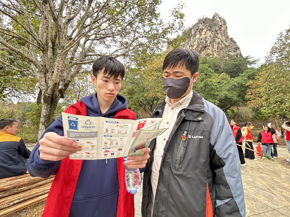 圖為志愿者宣傳垃圾分類環(huán)保理念.jpg