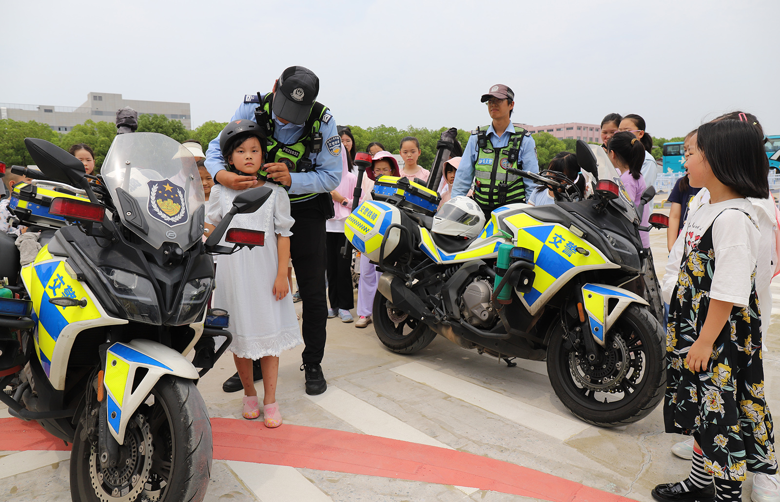 圖為交警叔叔在手把手教工娃們正確佩戴頭盔。02.JPG