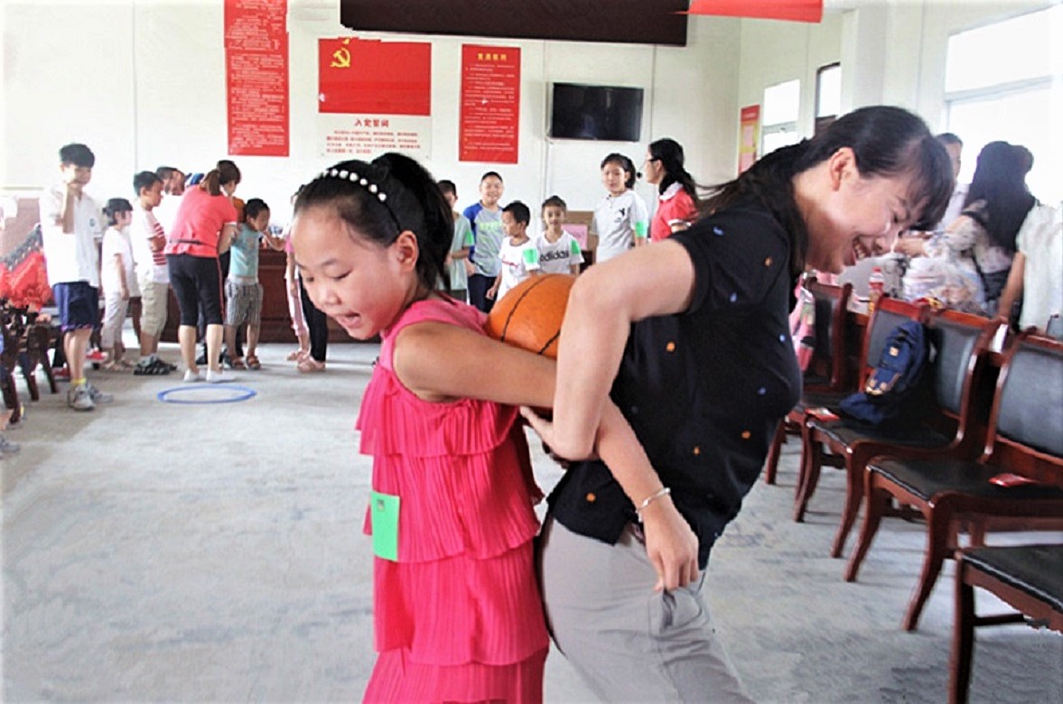 家長志愿者正在和孩子們做“雙臂傳球”游戲.JPG